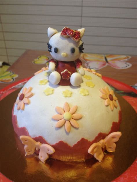 a hello kitty cake sitting on top of a red and gold plated platter