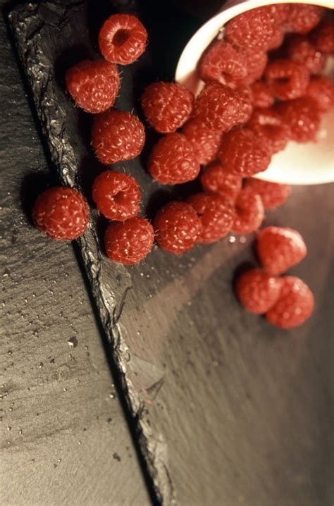 Ripe raspberries spilling from a container - Free Stock Image