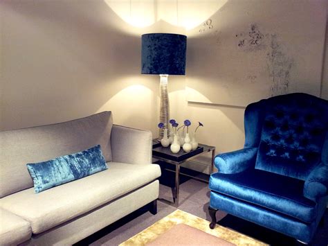 black shade clear glass base table lamp and beige sofa and blue satin ...