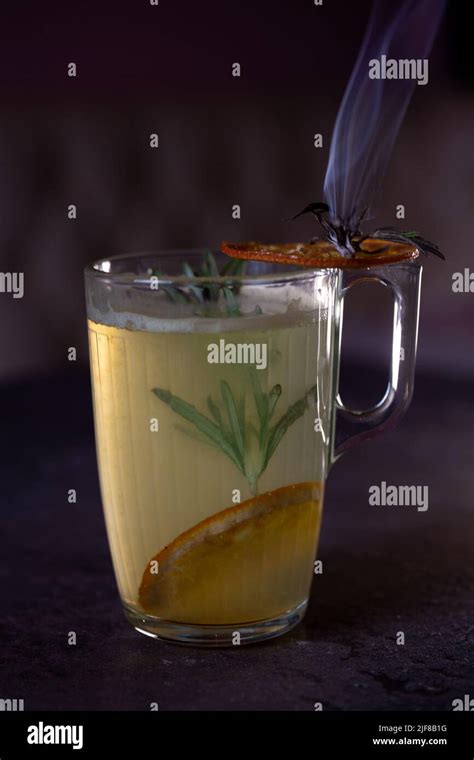 hot drink cocktail with a sprig of rosemary and lemon Stock Photo - Alamy