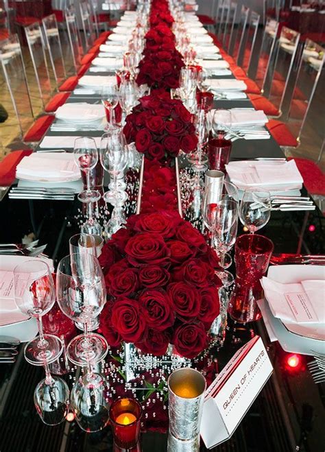 Table runners were created out of a seemingly endless array of alternating red rose petals and ...