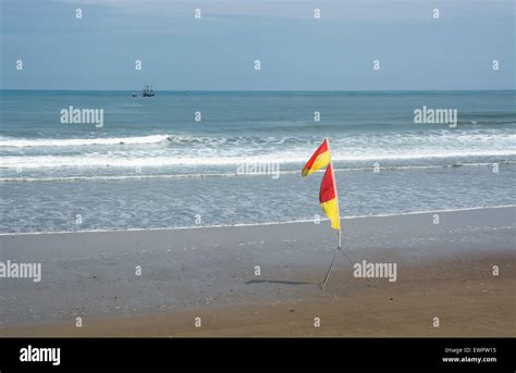 Yellow and red flag on the beach Stock Photo - Alamy