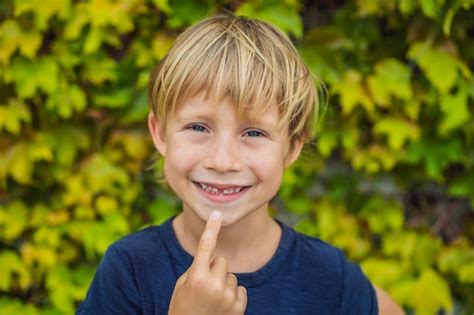 Premium Photo | Little smiling child boy hand pointing his first baby milk or temporary tooth ...