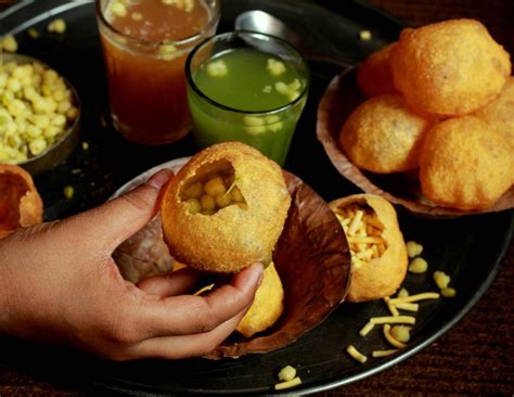 a person holding food in their hand on a plate with other foods and ...