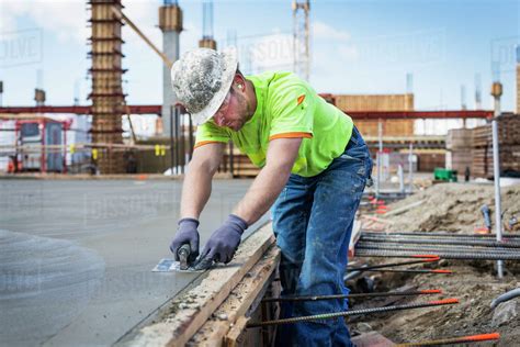 Construction worker finishing concrete at construction site - Stock ...