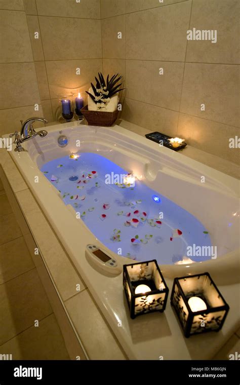 Romantic bubble bath with roses petals and candles for aroma therapy ...