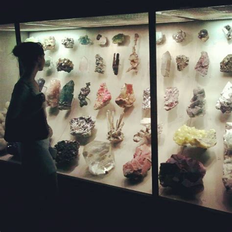 a woman standing in front of a display case filled with lots of ...