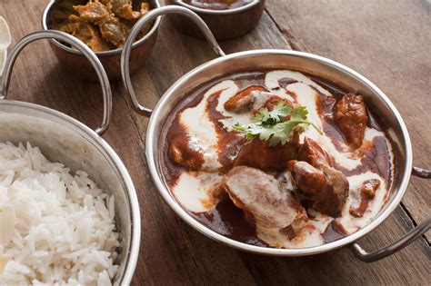 Creamy sauce on cooked chicken with rice on table - Free Stock Image