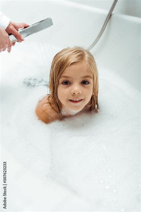 adorable and naked child taking bath near mother in bathroom Stock ...