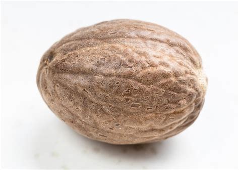 Premium Photo | Single whole nutmeg fruit close up on gray