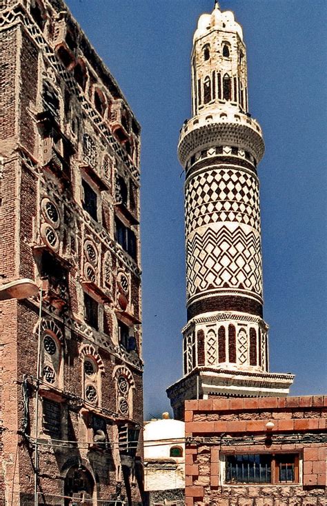 a tall tower with a clock on it's side next to another building in the city