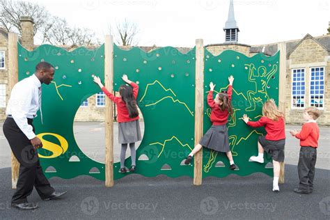 Children On Climbing Wall In School Playground At Breaktime 958277 Stock Photo at Vecteezy