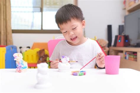 Premium Photo | Cute happy little Asian toddler boy child painting color on DIY plaster painting toy
