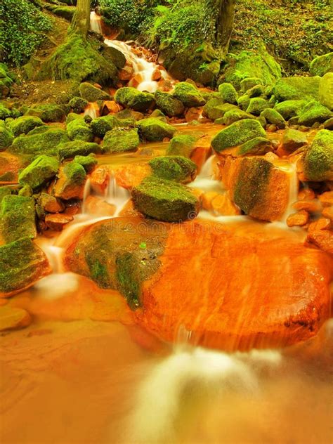 Spring Cascades in Rapid Stream of Mineral Water. Red Ferric Sediments on Big Boulders Stock ...