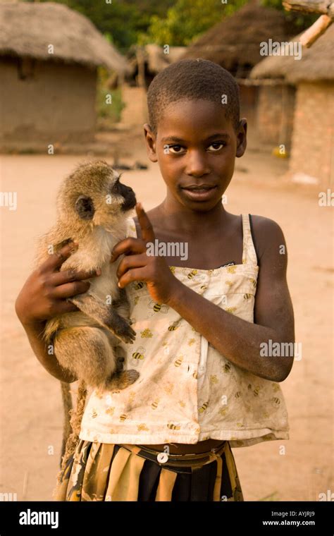 Young African girl with a pet monkey in her village Louloboka beside Lake Victoria Uganda Stock ...