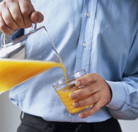 Pouring orange juice - Stock Image - P920/0493 - Science Photo Library