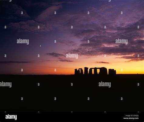 A wide landscape view of the Stonehenge trilithons silhouetted after sunset and moonrise Stock ...