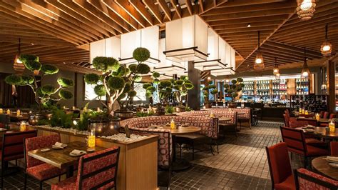 the interior of a restaurant with tables, chairs and potted plants ...