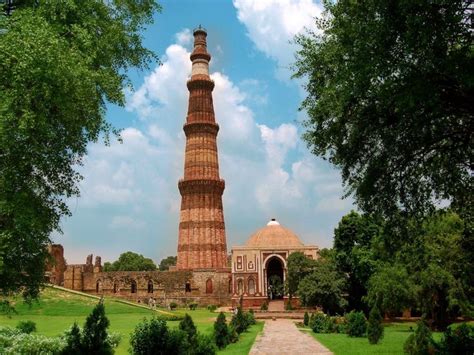 a tall brick tower sitting in the middle of a lush green field next to ...