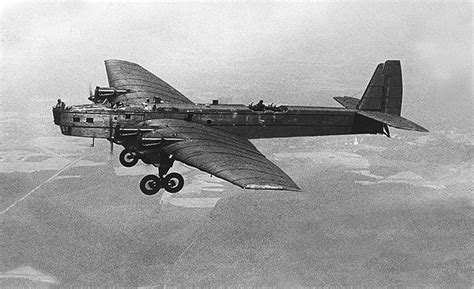 an old airplane flying in the sky over land