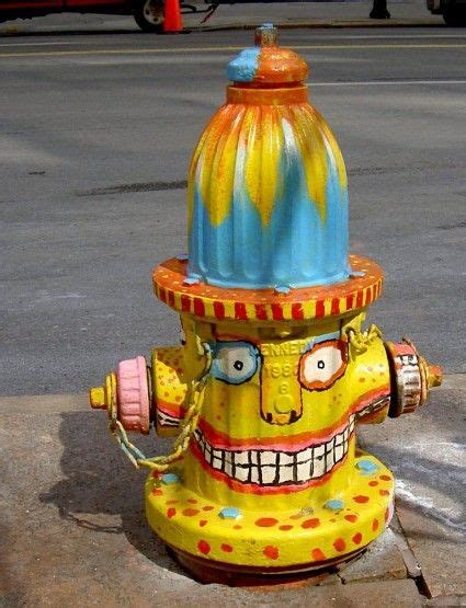 a yellow fire hydrant with a face painted on it