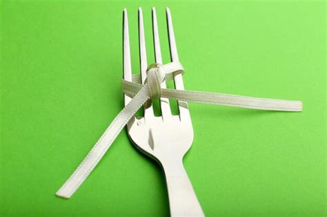 Premium Photo | Stages of tying bow on fork on green background closeup