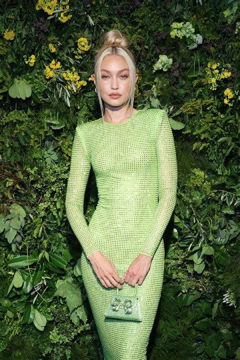 a woman in a bright green dress poses for the camera with her hand on ...