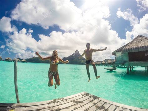 Bora Bora Island in French Polynesia. Happy people jumping in th ...