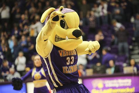 the mascot is wearing a purple uniform and holding his hand up in the ...