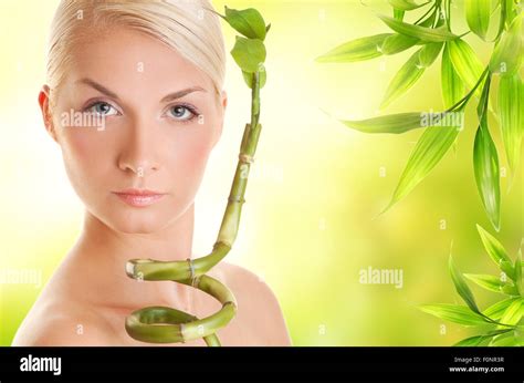 Beautiful young woman with bamboo plant Stock Photo - Alamy