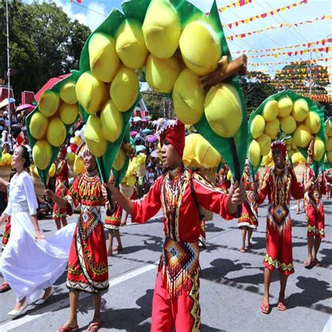 Street dancers wave giant "lanzones" during a parade in celebration of ...