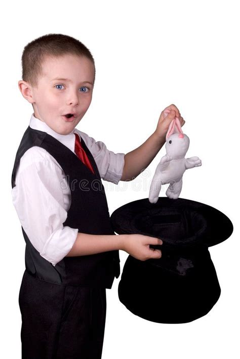 Child Magician. Child dressed as a magician pulling a rabbit from his ...