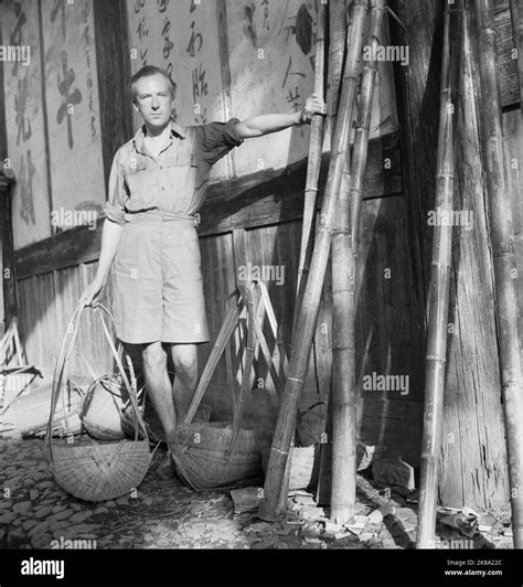 Cecil Beaton - Cecil Beaton (in shorts and shirt) with wicker baskets beside a wall with Chinese ...