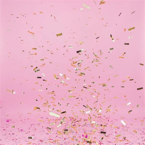 Free Photo | Falling golden confetti on pink background