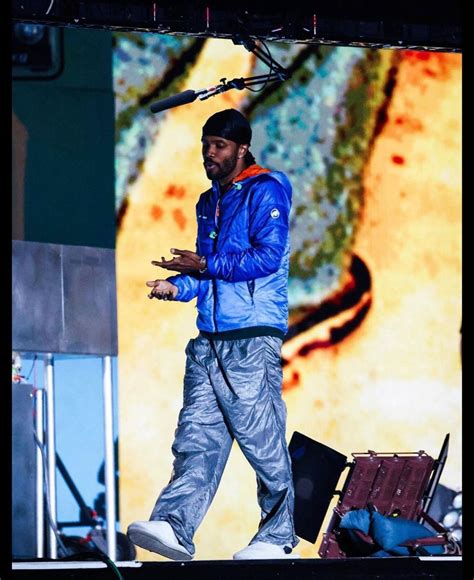 a man standing on top of a stage with a microphone in his hand and an ...