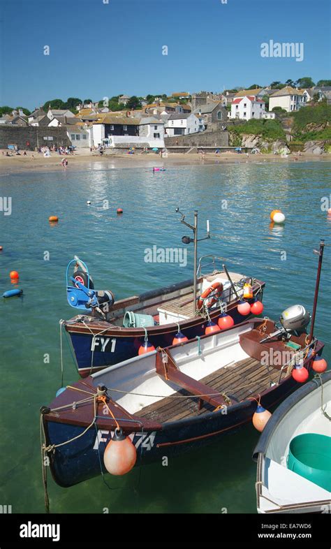 Small fishing boats moored alongside the quay at Gorran Haven harbour at high tide on a sunny ...