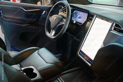 The interior of a Tesla electric car with steering wheel and dashboard ...