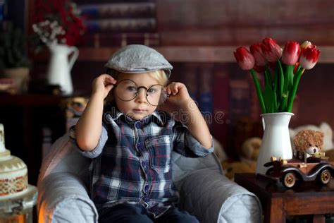 Sweet Toddler Boy, Wearing Glasses, Reading a Book and Drinking Tea with Cookies Stock Image ...