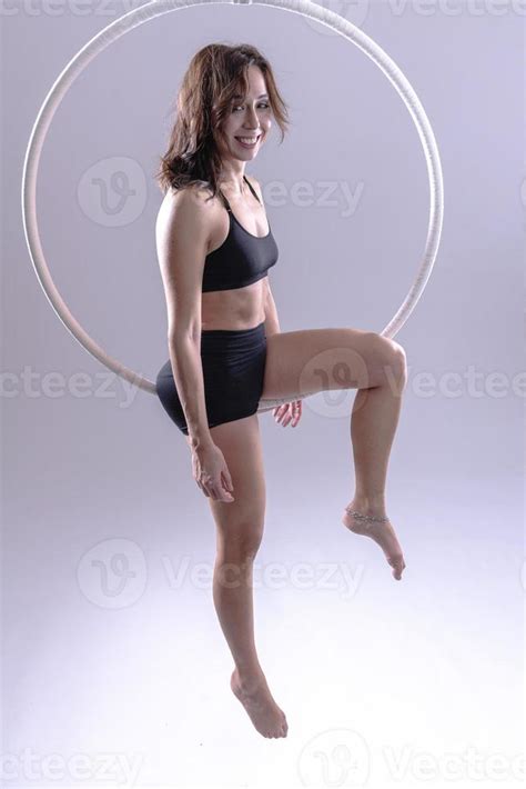 A female Aerial hoop gymnast performing exercises on an Aerial hoop ...