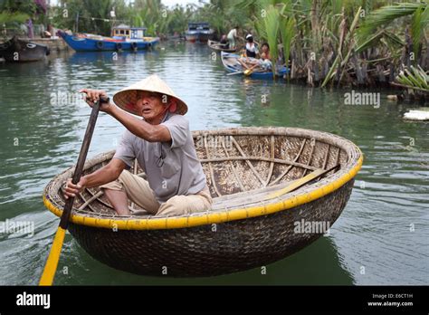 Vietnamese man in Non La hat rowing bamboo boat in Hoa An Vietnam Stock Photo - Alamy