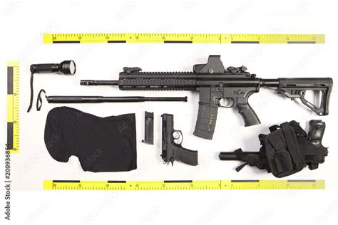 Police photo evidence of seized automatic gun and other weapons and ...