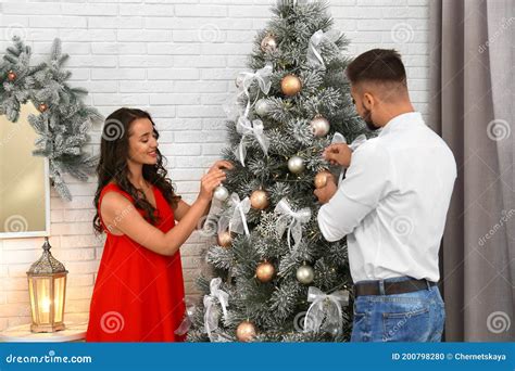 Happy Couple Decorating Christmas Tree Together at Home Stock Photo ...