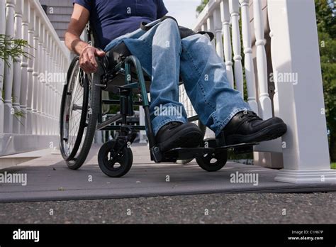 Man with spinal cord injury in a wheelchair on the top of home access ramp Stock Photo - Alamy