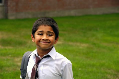 2376099 – a happy indian school kid smiling in front of the classroomr ...