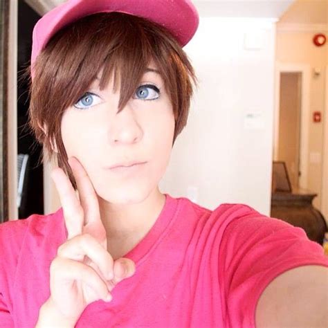 a woman in a pink shirt and hat posing for the camera with her hand on ...