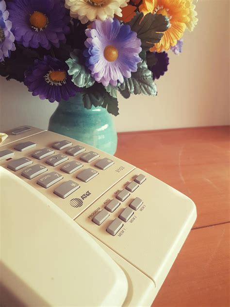 Free stock photo of artificial flowers, phone, sidetable