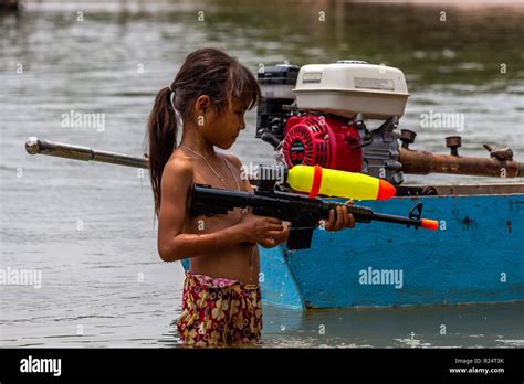 Don Det, Laos - April 25, 2018: Shirtless girl playing with a water ...