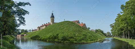 Moat of old castle. Moat with reflection in the water and trees. Sunny summer day. Palace, tower ...