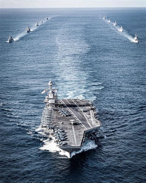 The battleship USS Oklahoma passes a Revenge class battleship on a visit to Portsmouth, UK, June ...