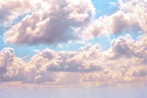 Illuminated fluffy pink clouds in a blue sky Photograph by Artpics